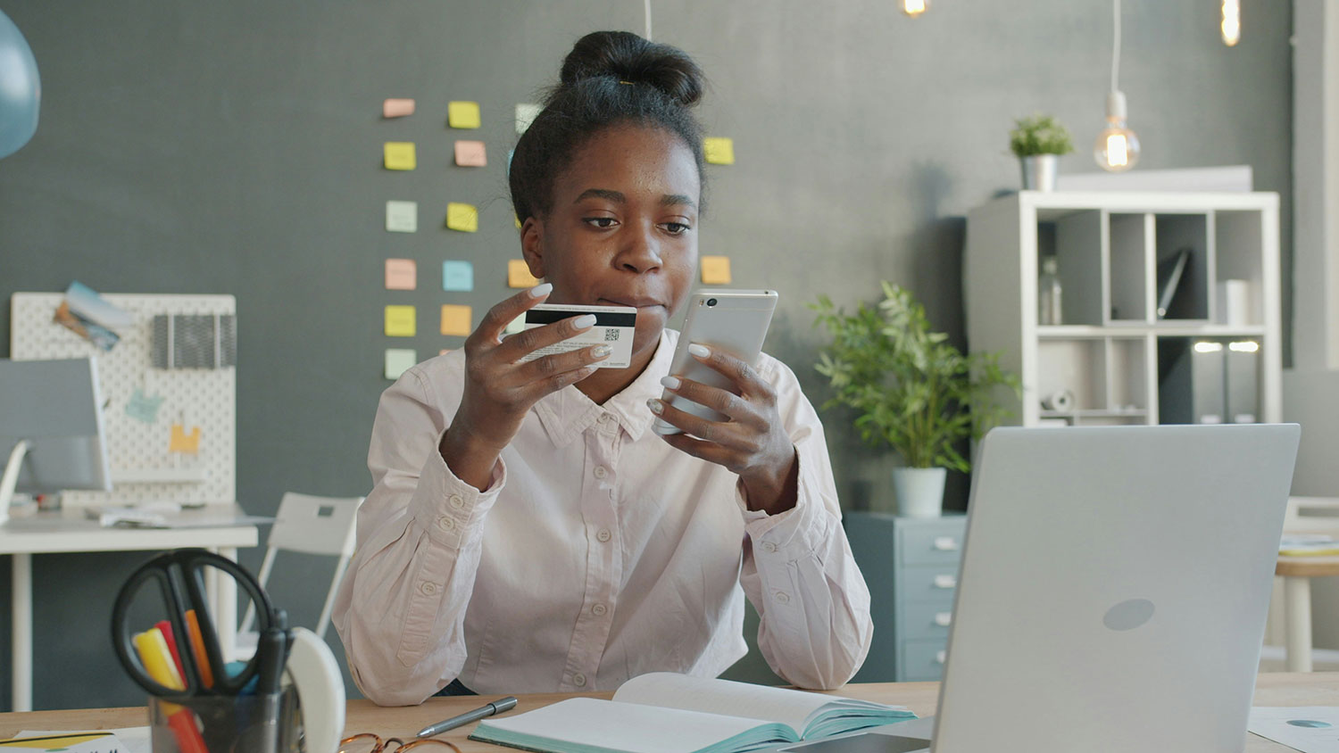 A woman holding a phone and card